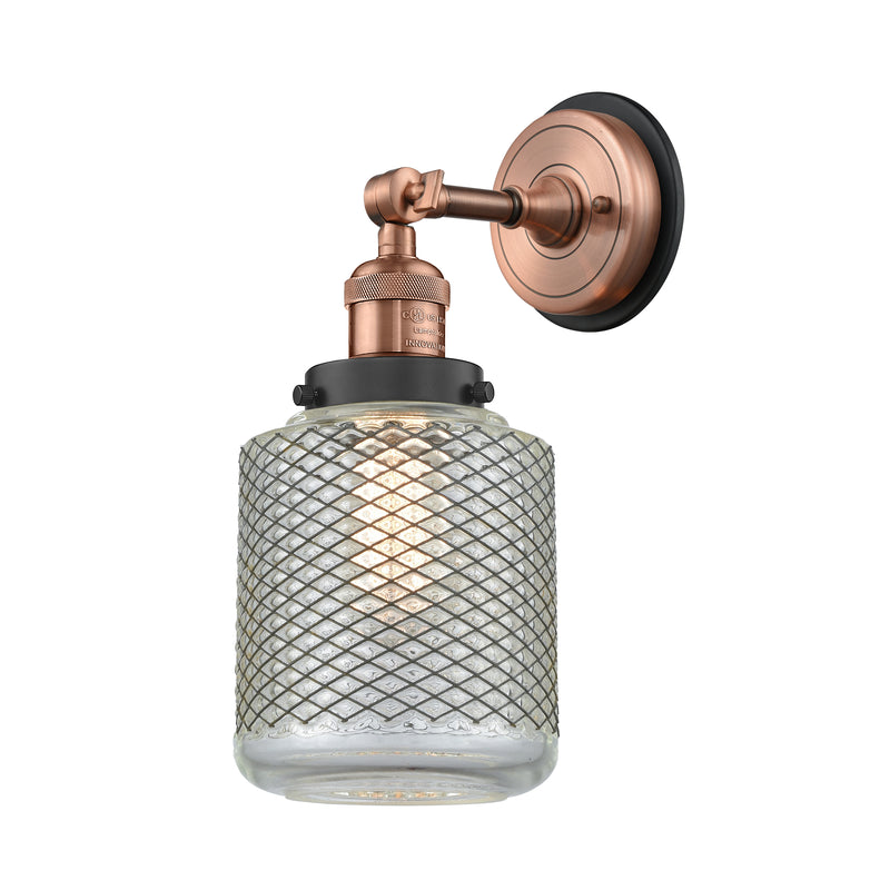 Stanton Sconce shown in the Antique Copper finish with a Clear Wire Mesh shade