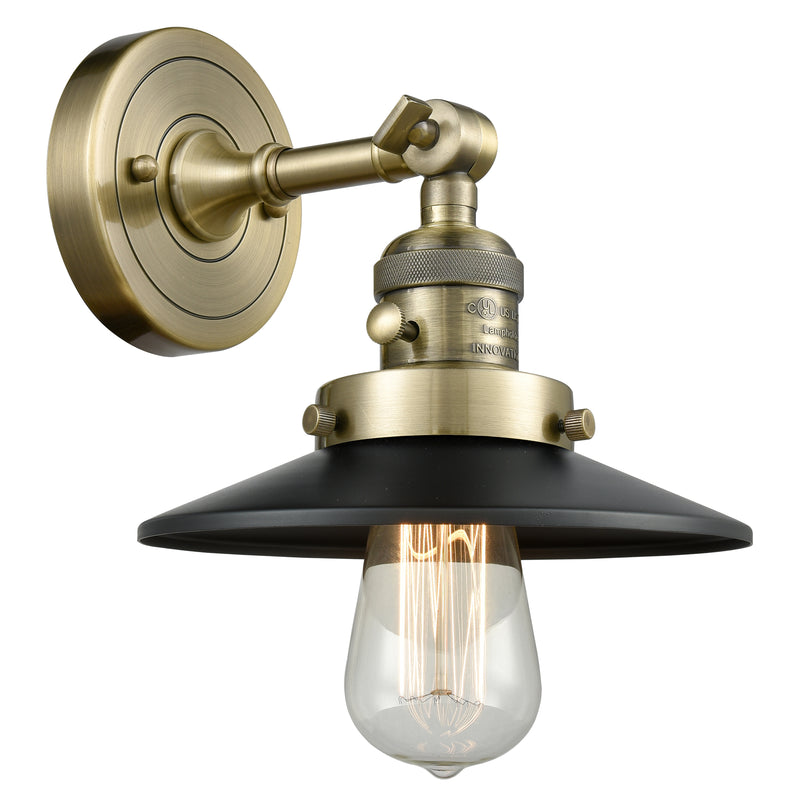 Railroad Sconce shown in the Antique Brass finish with a Matte Black shade