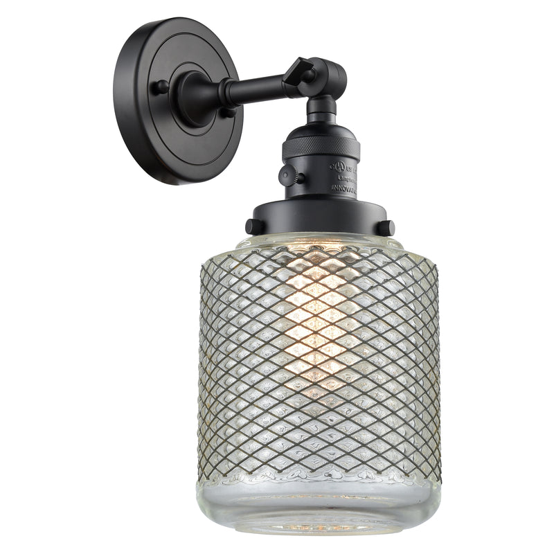 Stanton Sconce shown in the Matte Black finish with a Clear Wire Mesh shade