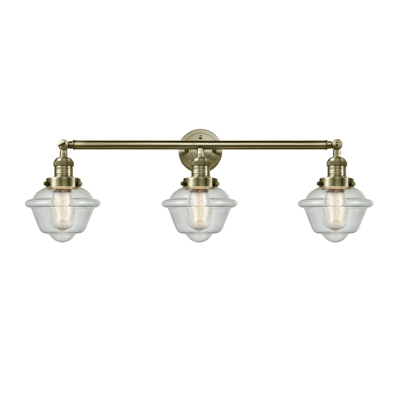 Oxford Bath Vanity Light shown in the Antique Brass finish with a Seedy shade