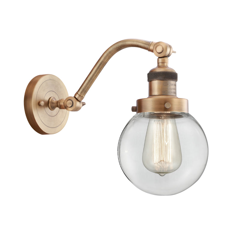 Beacon Sconce shown in the Brushed Brass finish with a Clear shade