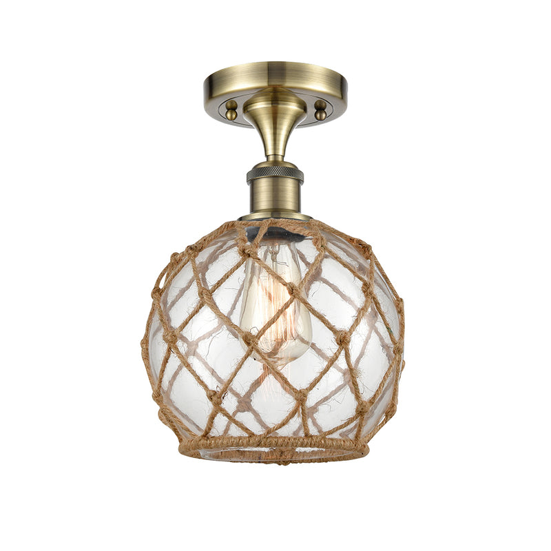 Farmhouse Rope Semi-Flush Mount shown in the Antique Brass finish with a Clear Glass with Brown Rope shade