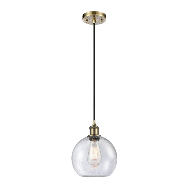 Athens Mini Pendant shown in the Antique Brass finish with a Seedy shade