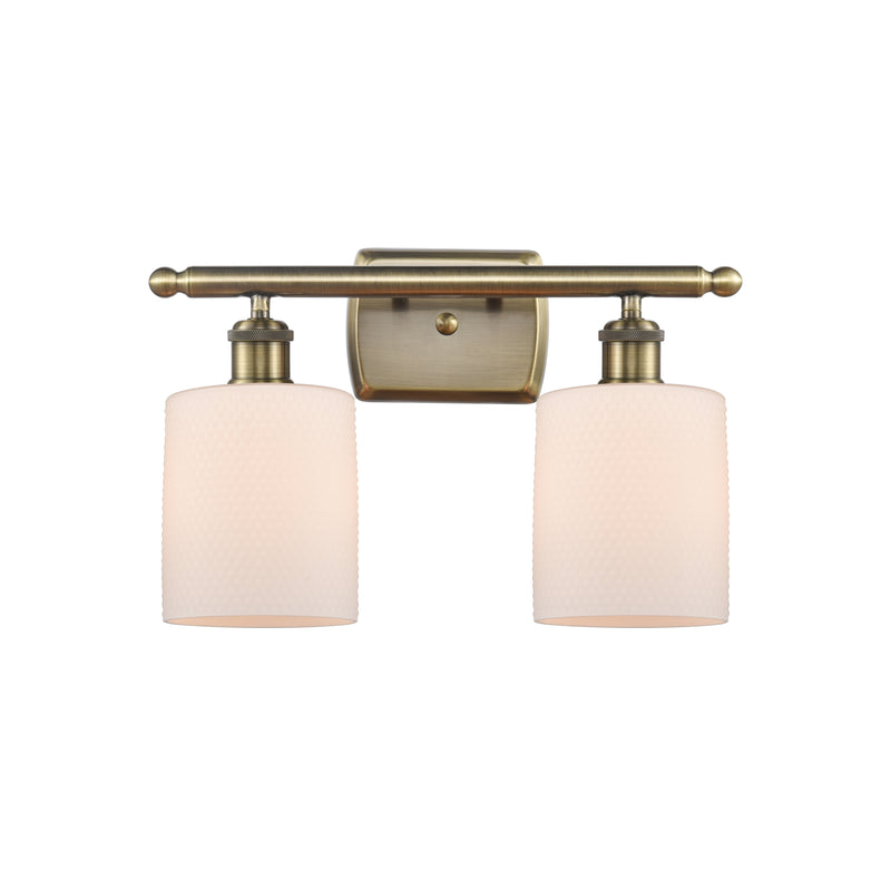 Cobbleskill Bath Vanity Light shown in the Antique Brass finish with a Matte White shade