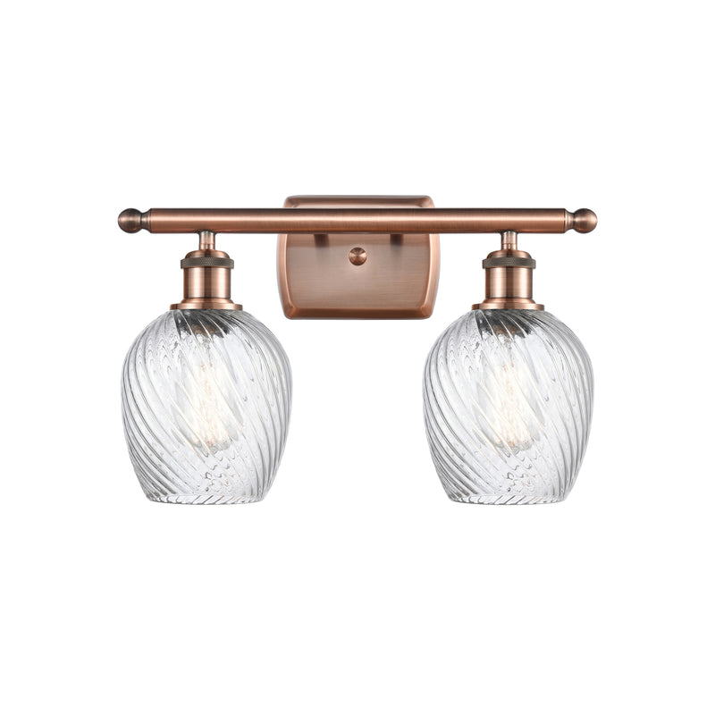 Salina Bath Vanity Light shown in the Antique Copper finish with a Clear Spiral Fluted shade