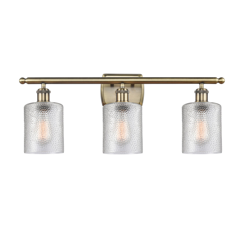 Cobbleskill Bath Vanity Light shown in the Antique Brass finish with a Clear shade