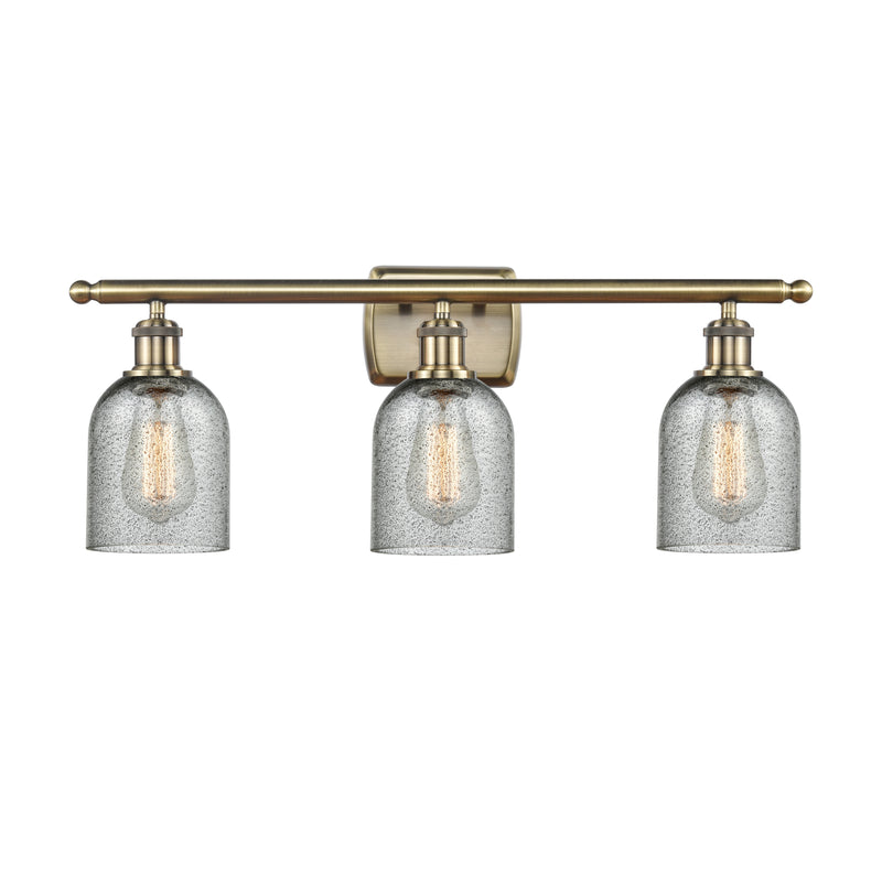 Caledonia Bath Vanity Light shown in the Antique Brass finish with a Charcoal shade