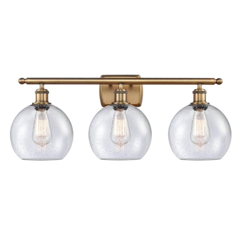 Athens Bath Vanity Light shown in the Brushed Brass finish with a Seedy shade
