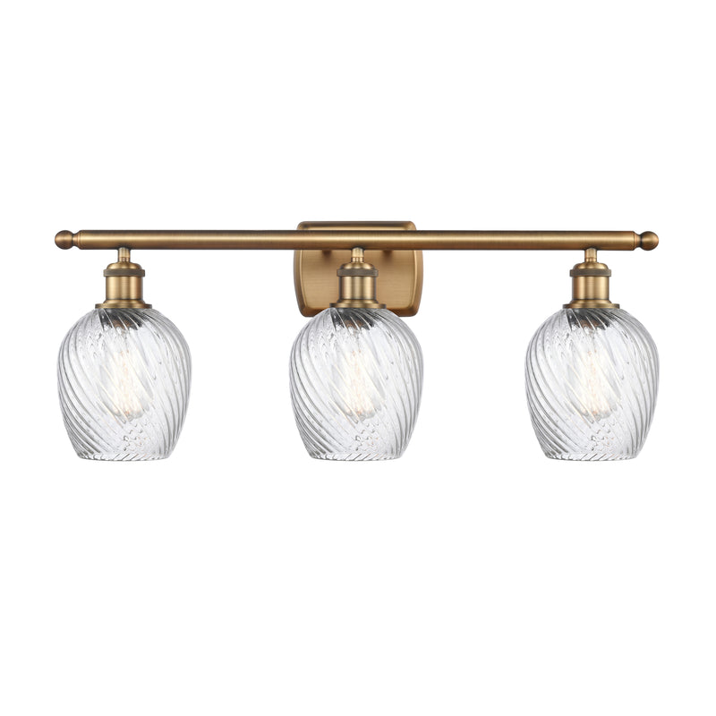 Salina Bath Vanity Light shown in the Brushed Brass finish with a Clear Spiral Fluted shade