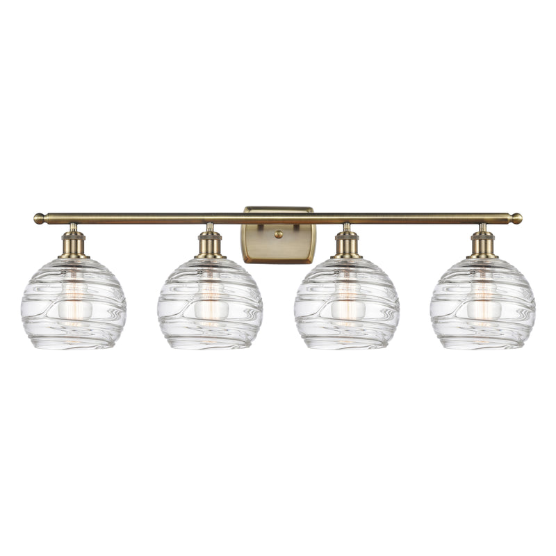 Deco Swirl Bath Vanity Light shown in the Antique Brass finish with a Clear shade