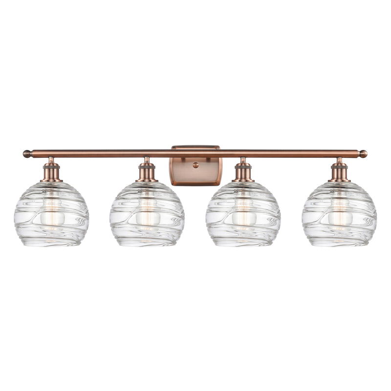 Deco Swirl Bath Vanity Light shown in the Antique Copper finish with a Clear shade