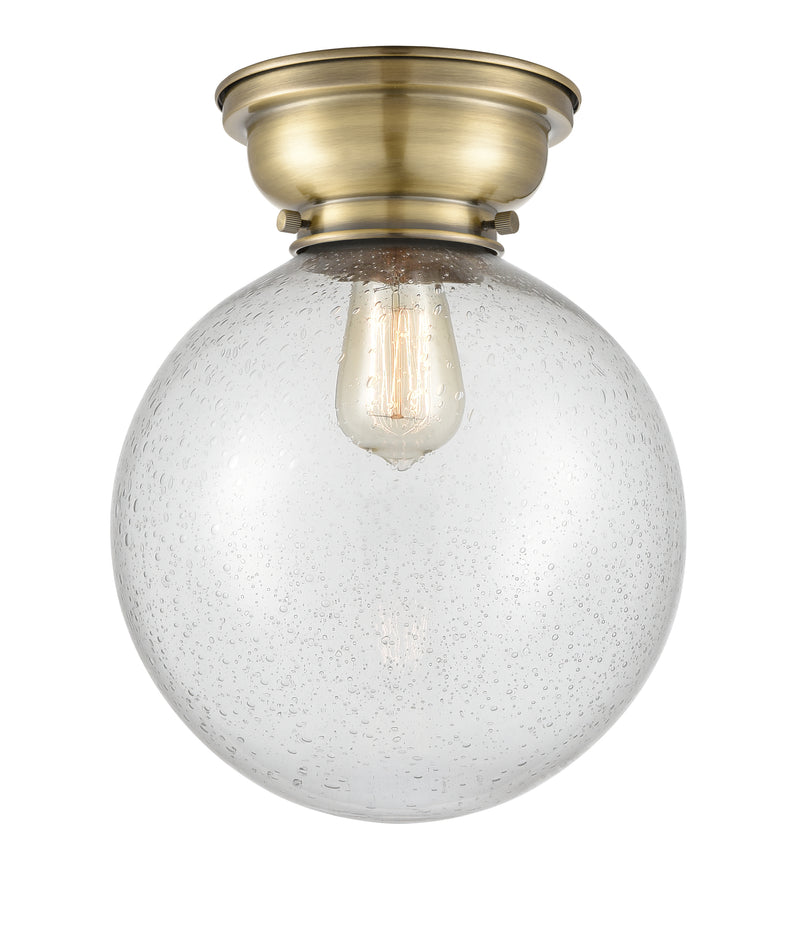 Beacon Flush Mount shown in the Antique Brass finish with a Seedy shade