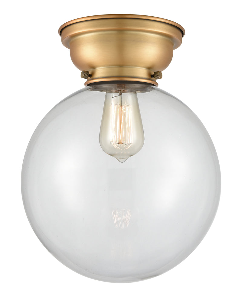 Beacon Flush Mount shown in the Brushed Brass finish with a Clear shade