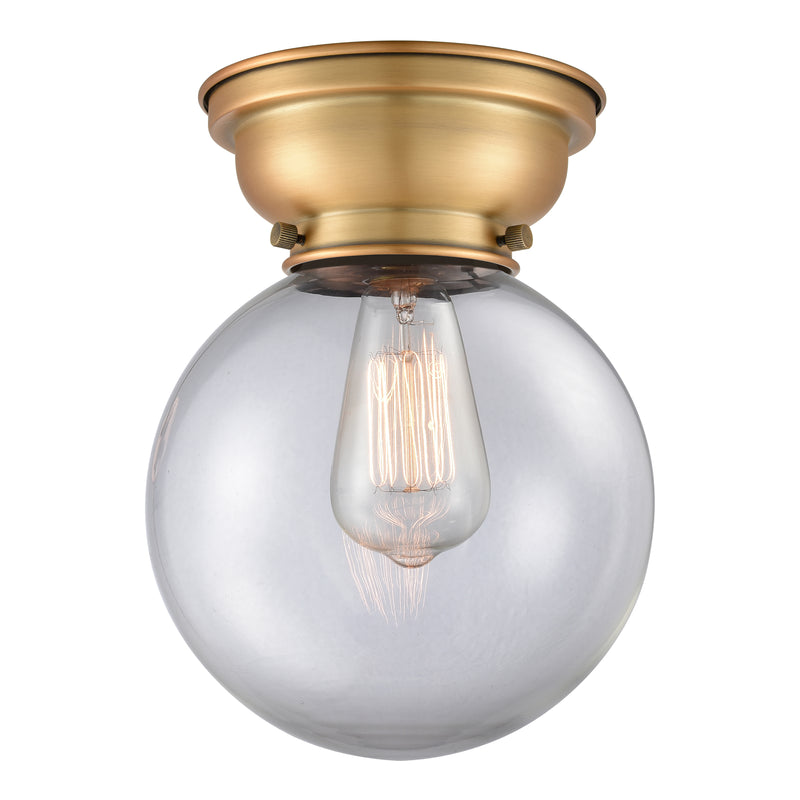 Beacon Flush Mount shown in the Brushed Brass finish with a Clear shade